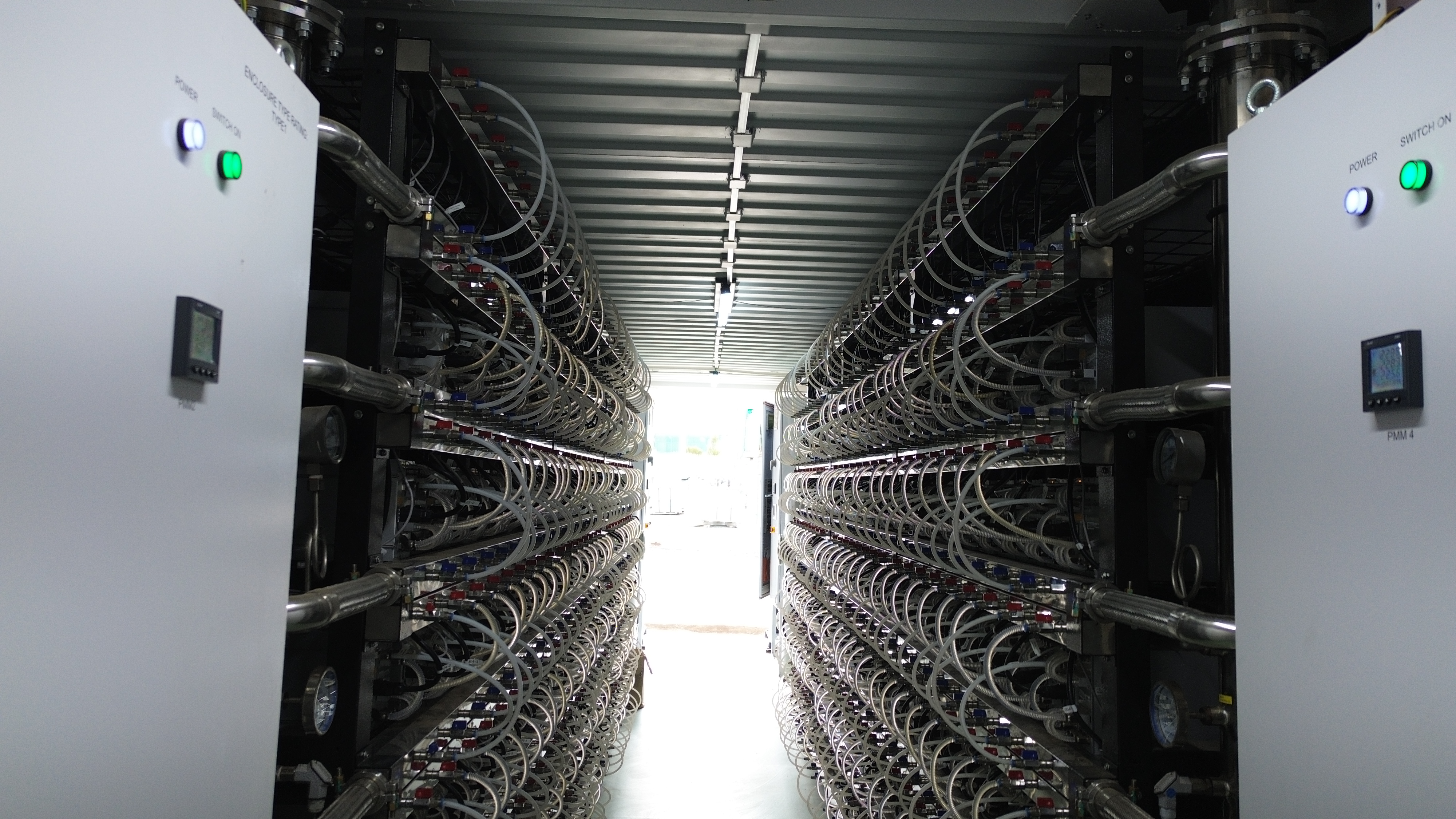 Hydro miner rows and electrical cabinets surrounding the central aisle